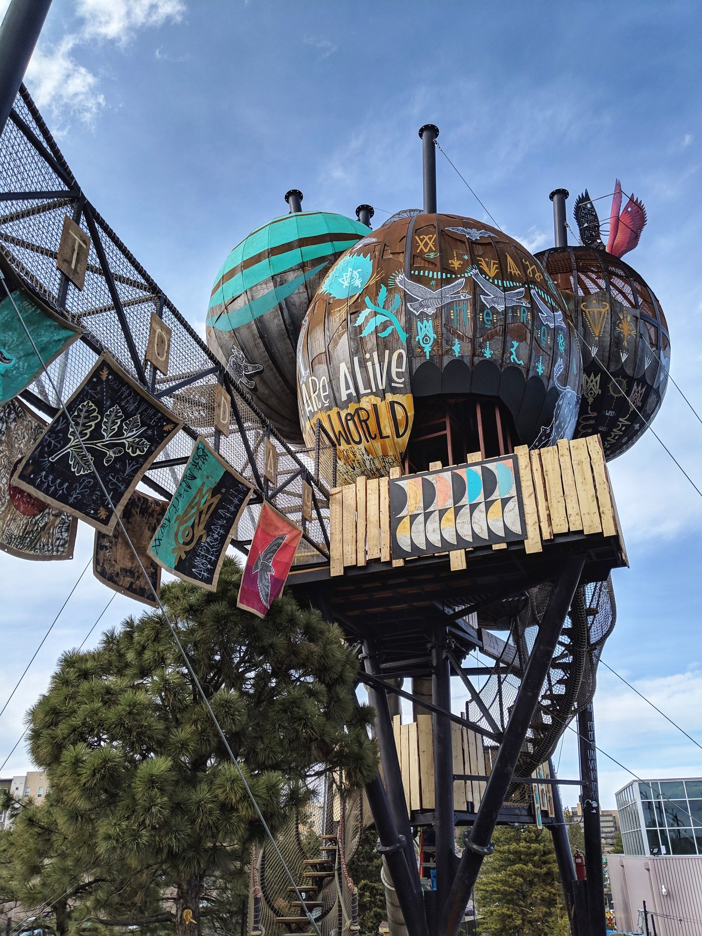 The Children's Museum of Denver's elevated tree-house-style exhibit structure against a blue sky.