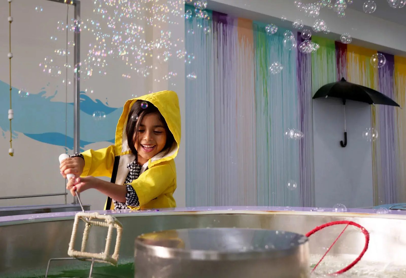 A child painting a vivid 3D-printed sculpture at the woo-hoo! museum in Dubai.